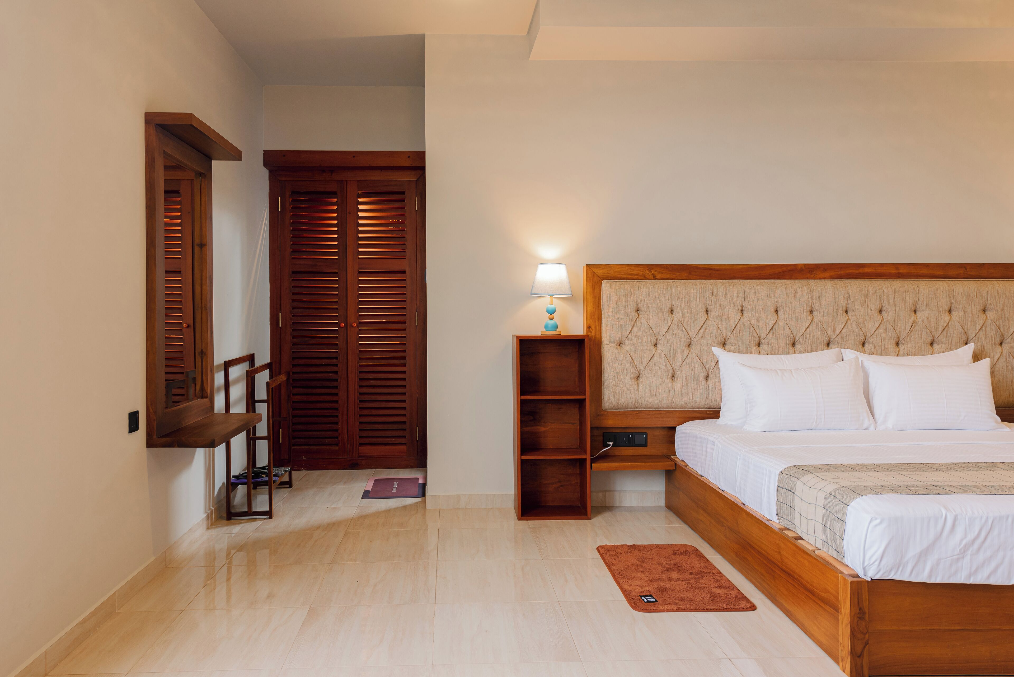 A bedroom with a wooden bed, a nightstand, a lamp, and a wardrobe.