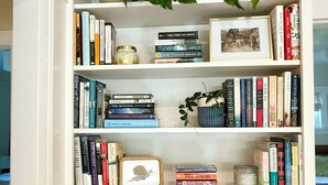 Une bibliothèque contenant divers livres et objets décoratifs.