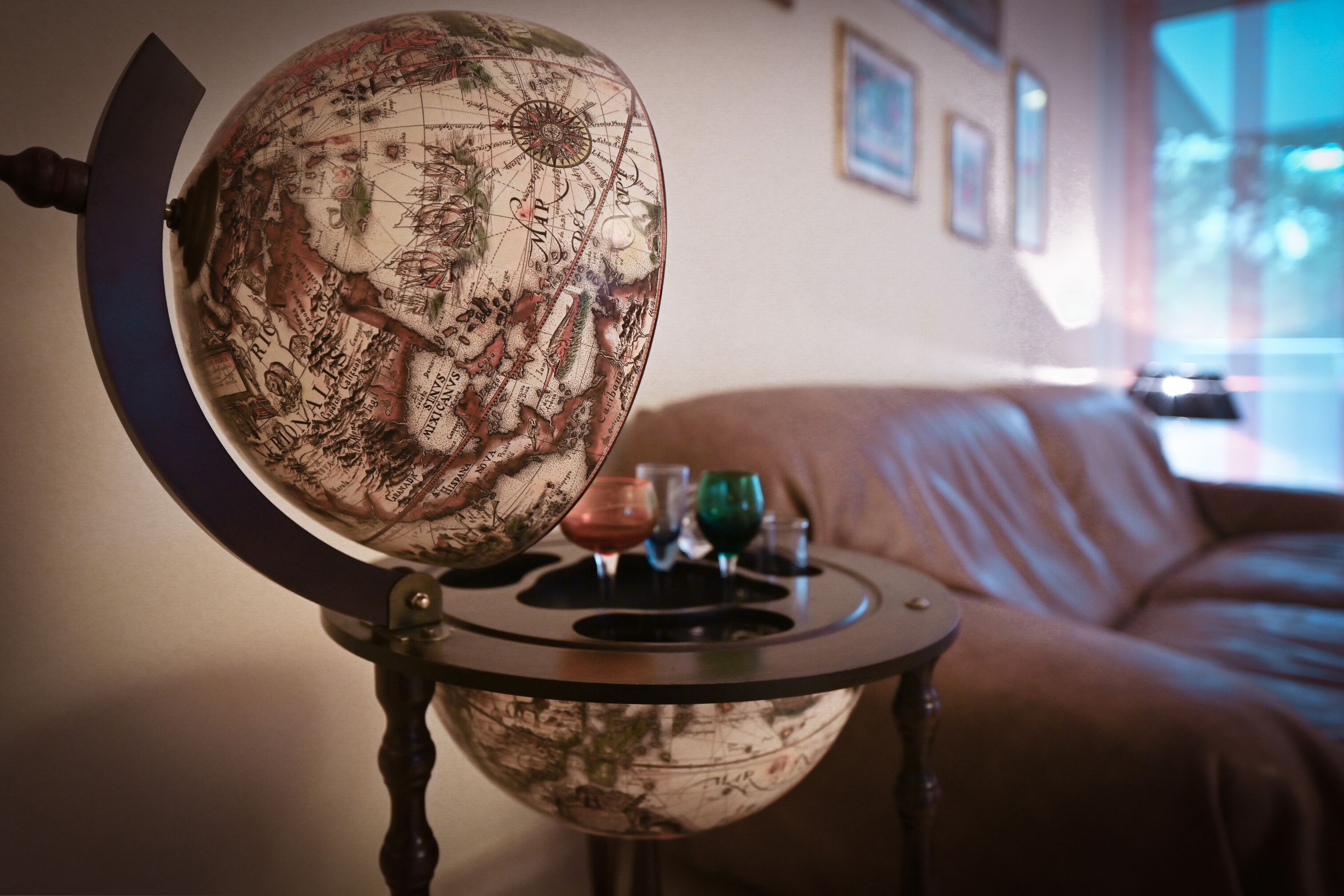 A globe on a table with a leather couch in the background.