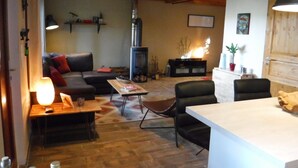 Ein gemütliches Wohnzimmer mit Kamin, einer Couch, einem Couchtisch und einem Essbereich.