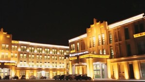 A hotel with a prominent entrance and multiple parking spaces. - Spring Hotel (Dacheng)