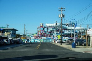 A street with a large amusement park ride in the background, a pedestrian crossing sign, and parked cars. - Double Room unit 1 (Wildwood)