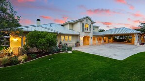 A two-story house with a large front yard, a covered porch, and a garage.