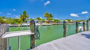 A marina with docked boats, a wooden pier, and palm trees. - Cabana Club, Kayaks, Pets, Boat Dock, Near Golf! (Key Colony Beach)