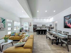 A modern living room with a sofa, dining table, and kitchen area. - Amazing Walkability, Thornton Park suburb of Downtown Orlando walk to everything (Orlando)
