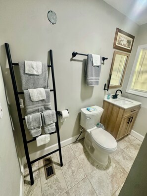 Een douche, handdoeken, zeep, toiletpapier