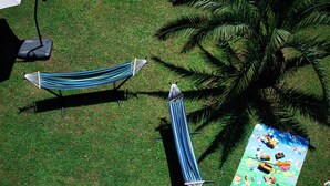 A hammock, a picnic table with a children's game, and a palm tree. - Pollux (Batumi)