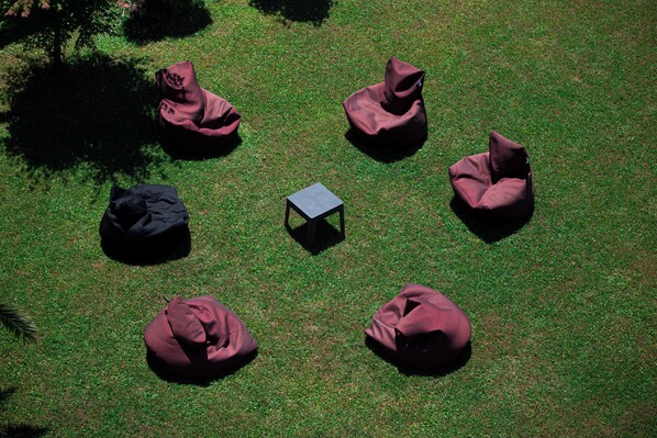 Des poufs disposés en cercle autour d’une petite table, le tout installé sur une pelouse.