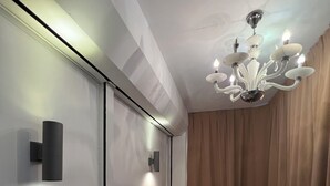 A modern interior with a sliding door, a chandelier, and red stools. - COMFORTABLE STAY HOME (Ayer Itam)
