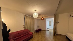 A spacious living area with a red sofa, a glass coffee table, and a hanging light fixture. - COMFORTABLE STAY HOME (Ayer Itam)