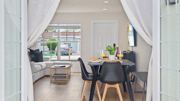 Un comedor moderno con una mesa para dos, un sofá y vistas al exterior.