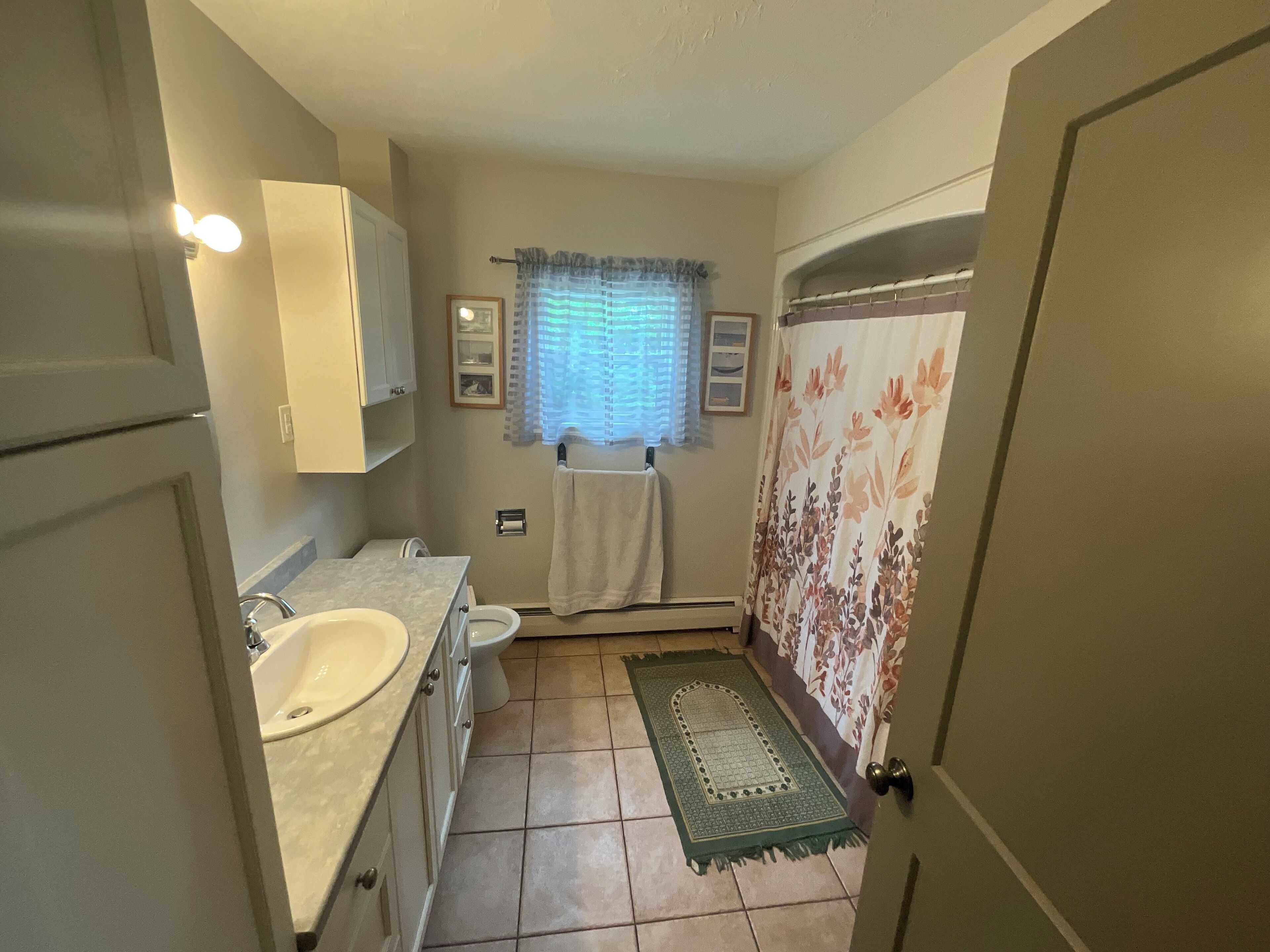 A compact bathroom with a sink, toilet, and shower area.