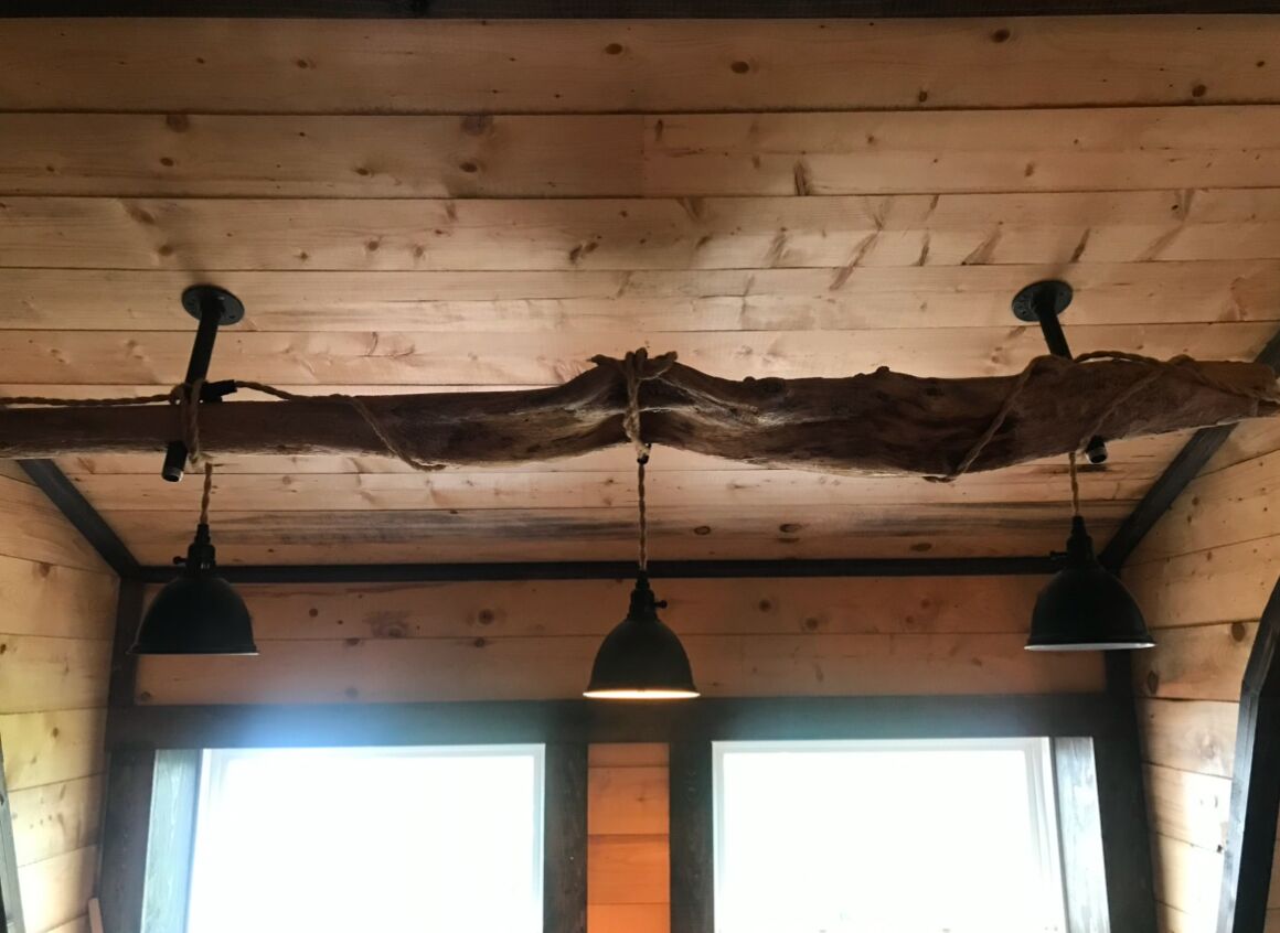 A wooden ceiling with exposed beams and pendant lights.