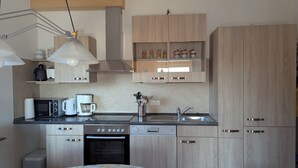 A modern kitchen with wooden cabinets, a microwave, a coffee maker, and a sink.