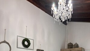 A bedroom with two beds, a chandelier, and wall decorations including a wreath and framed items. - Cozy triple room (Veneto)