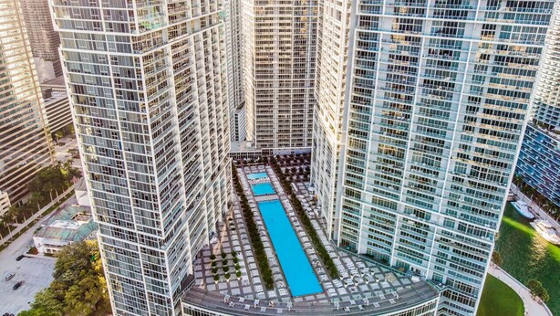 A high-rise building with a central courtyard featuring a long, narrow pool. - Icon Brickell Retreat | 1BR + Spa, Pool, Views (Miami)