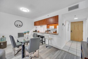 A modern kitchen with wooden cabinets, a built-in microwave, and a stainless steel sink.