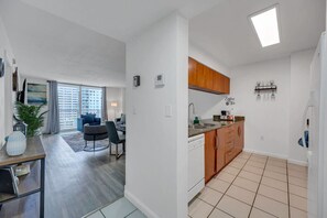 Un apartamento moderno con comedor, cocina y balcón con vista a la ciudad.