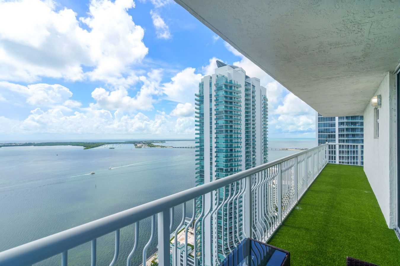 A balcony with a view of a tall building and a body of water.