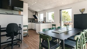 Eine moderne Küche mit weißen Schränken, einer schwarzen Arbeitsplatte und einem großen Fenster.