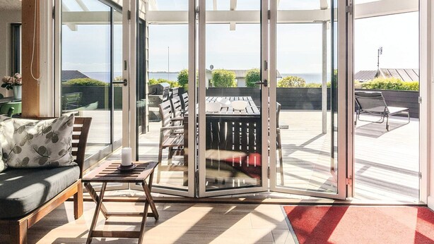 Ein modernes Wohnzimmer mit Glastür, die auf eine Terrasse führt.