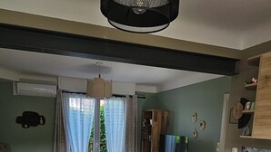 Een moderne keuken met een eethoek, houten vloeren en een groot raam met gordijnen.