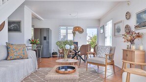A spacious living area with a sofa, chairs, a coffee table, and a dining table.