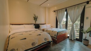 A hotel room with two beds, a potted plant, and a view through large windows. - UNLTD Hotel Siargao (General Luna)