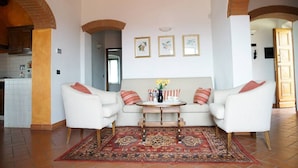 Een gezellige woonkamer met een zithoek, een salontafel en een kamerkleed.