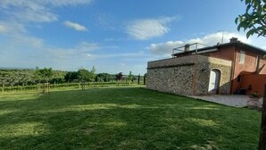 Een huis met een stenen gevel, een kleine tuin en een helderblauwe lucht.