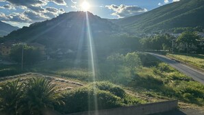 A mountainous landscape with a road leading to a settlement.
