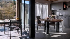 A modern kitchen with a dining area, large windows, and a view of the outdoors. - Villa in Ardennes Near Scenic Forest Trails (La Roche-en-Ardenne)
