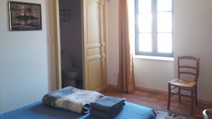 A bedroom with a bed, a chair, a window, and a door. - In the heart of the Ardeche river (Vogüé)