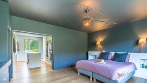 Une chambre à coucher moderne avec un grand lit, deux lampes de chevet et un luminaire au plafond original.
