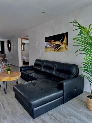 Relax in this stylish living room with a comfortable sofa, coffee table, and potted plant.