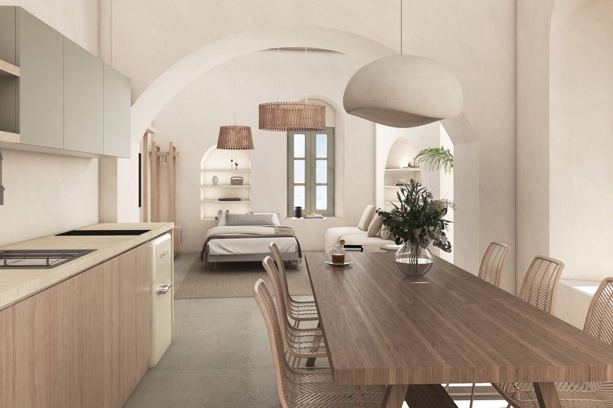 Una cocina moderna con una isla, un comedor con mesa y sillas de madera, y una sala de estar con sofá y un ventanal grande.