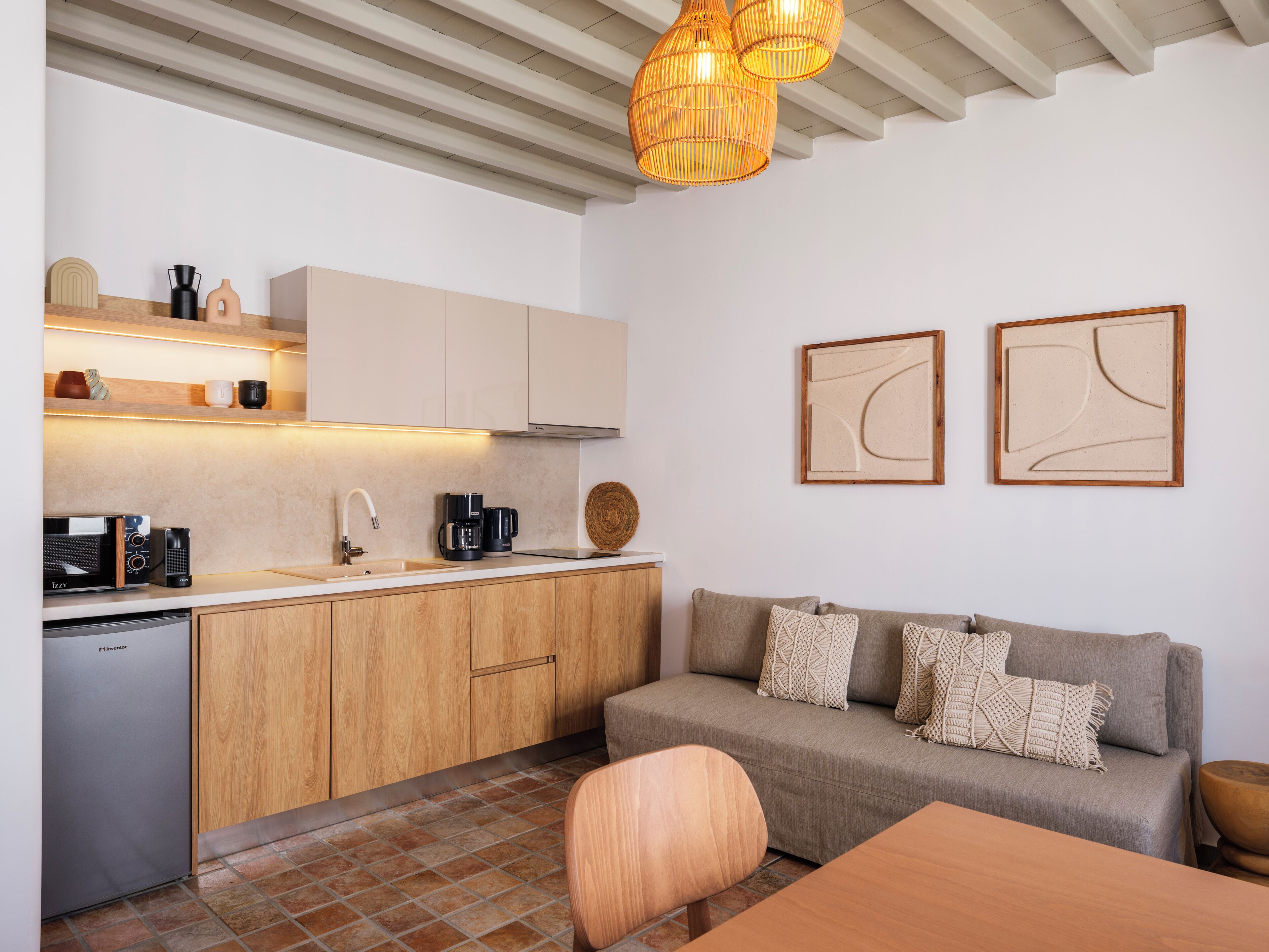 Une cuisine moderne avec des meubles en bois, un lave-vaisselle encastré et un coin repas comprenant une table et des chaises en bois.