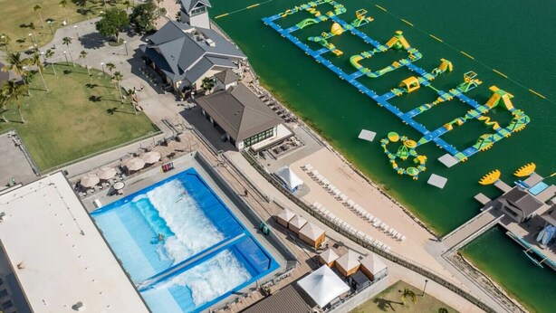 Vista aérea de un complejo turístico con una gran piscina, parque acuático y zona de playa.