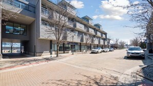Un immeuble moderne à plusieurs étages, doté d’un toit plat et de grandes fenêtres.