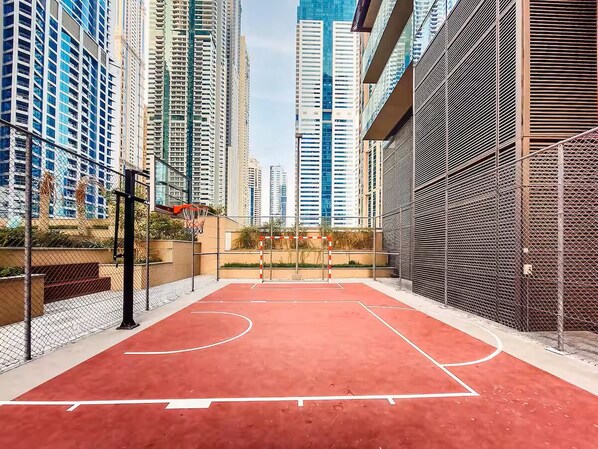 Una cancha de baloncesto al aire libre rodeada de edificios altos.