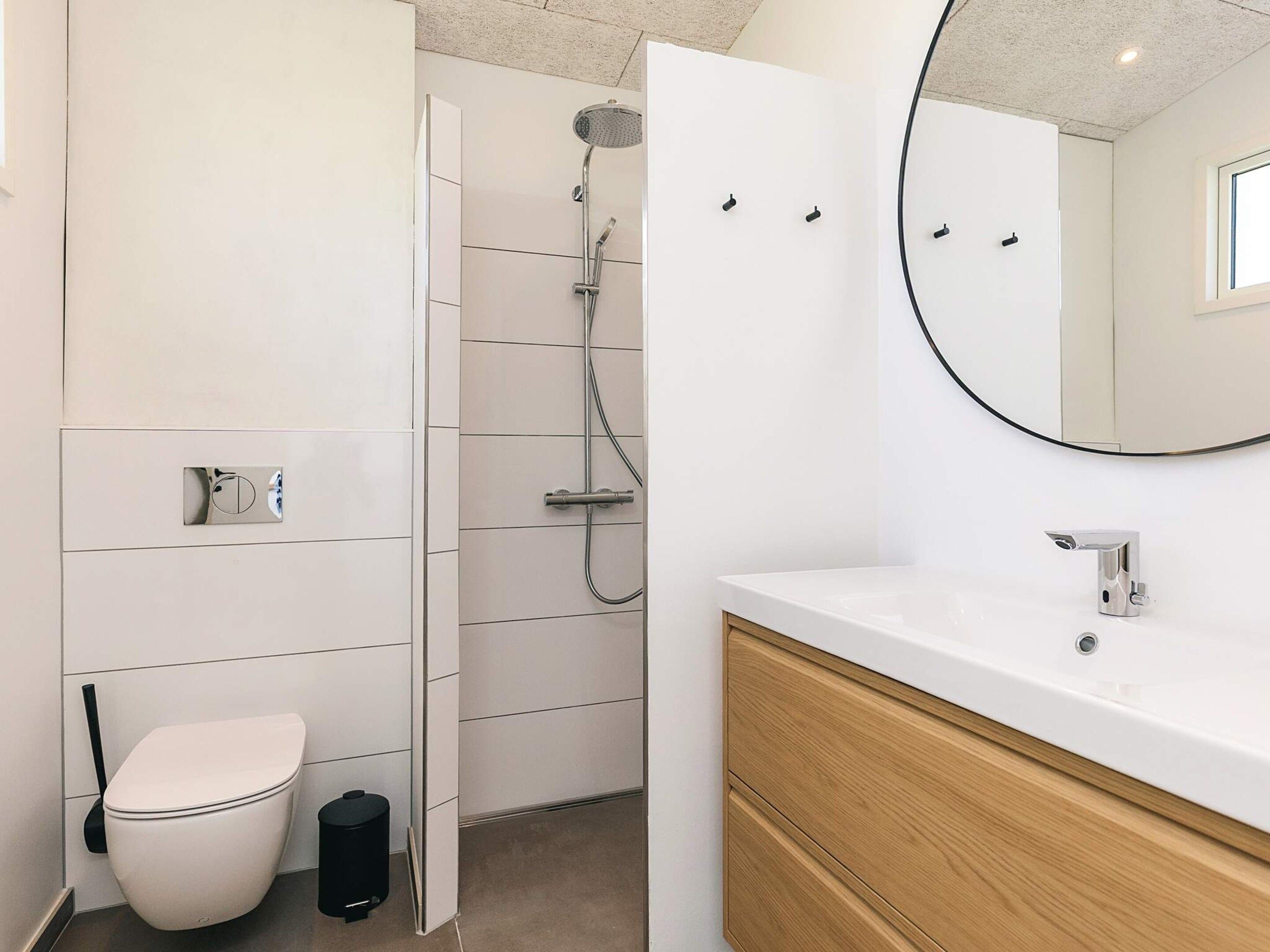 A modern bathroom with a toilet, shower, and sink.