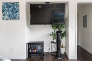 Relax in this stylish living room with a flat-screen TV, abstract art, and a potted plant.