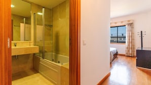 Un baño con cabina de ducha de vidrio, un lavabo y un espejo.