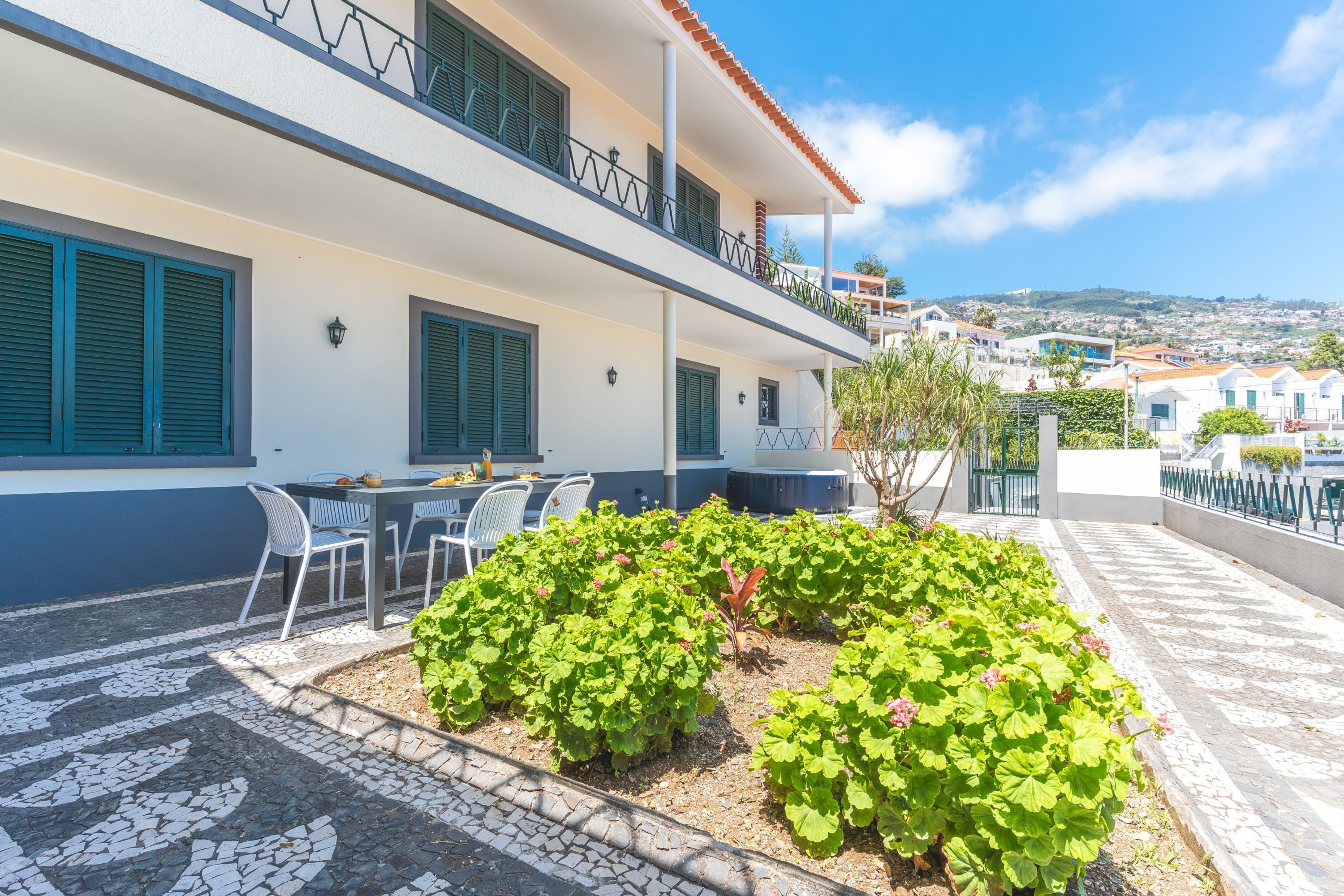 A hotel with a terrace featuring outdoor seating and a garden.