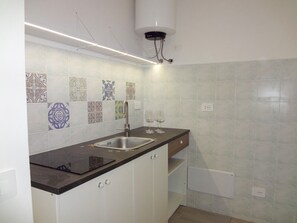 Kylskåp, spishäll, kaffe- och tebryggare och grytor/köksredskap