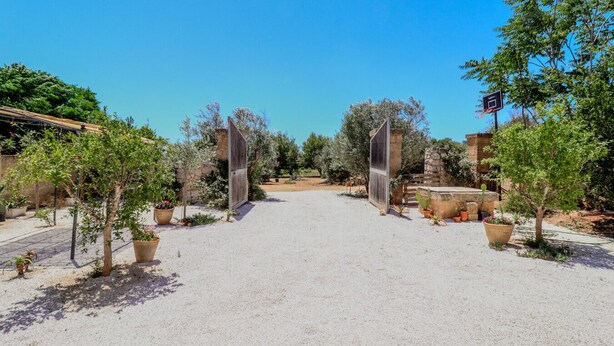 A gravel driveway leading to a gated entrance with potted plants and a stone wall. - Pajara La Fava - Apulia (Capilungo)