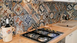 A kitchen with a gas stove, oven, and a tiled backsplash. - Pajara La Fava - Apulia (Capilungo)