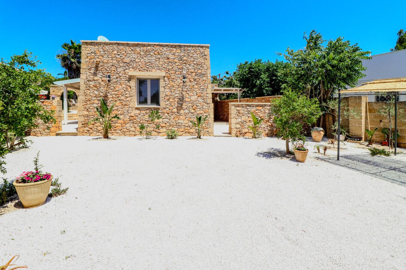 A stone building with a window and a covered patio area.