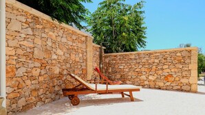 A stone-walled outdoor area with a sun lounger and a cart. - Pajara La Fava - Apulia (Capilungo)