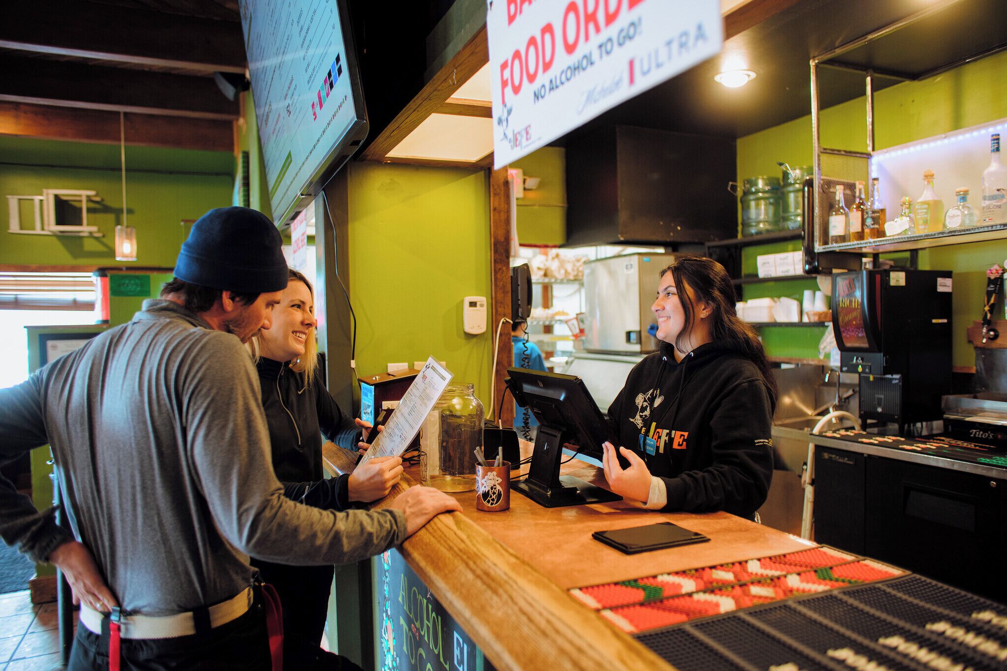 A bar with a menu, a cash register, and a sign indicating no alcohol.